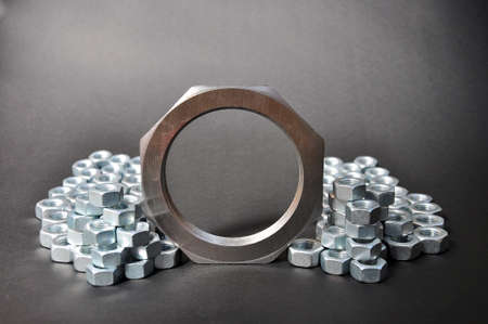 Composition of metal nuts on a dark background
