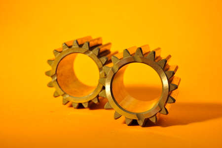 Metallic cogwheels on a colored background.