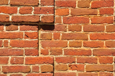 A fragment of a brick wall made of red bricks. Background image.の写真素材
