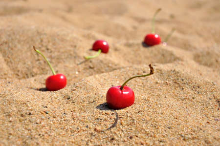 Ripe cherry berries on golden sand.の写真素材