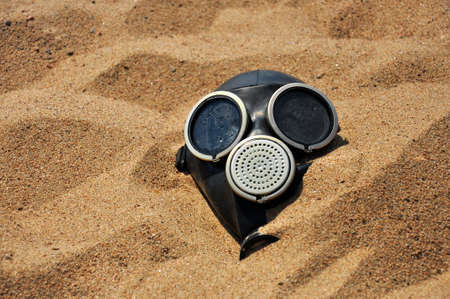 The problem is environmental pollution. Gas mask on the sand in the desert.の写真素材