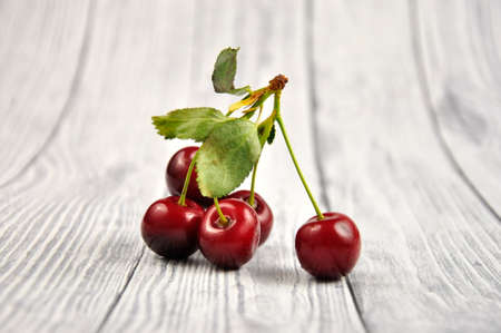 A ripe red cherry on a gray wooden table.の写真素材