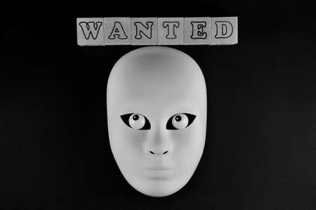 Financial fraud crime. The white mask of a fraudster. The inscription is wanted.の写真素材