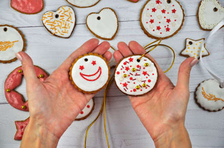 Hands of female with gingerbread cookies. Close up. Homemade traditional Christmas pastries