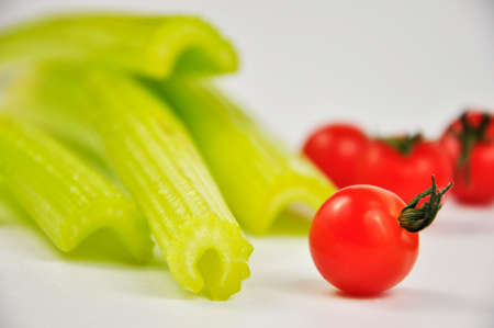 Fresh green Celery and cherry Tomatoes on white background. Food for healthy concept. Blurry...