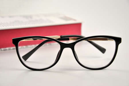 Glasses and book on white background.