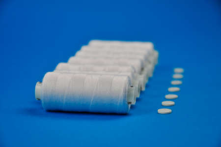 White thread spools and buttons for sewing clothes. blurring.