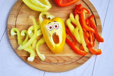 Sweet bell pepper sliced on a wooden chopping board.の写真素材