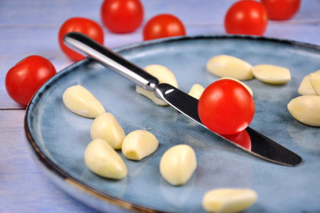 Cherry tomatoes and garlic on a plate.の写真素材