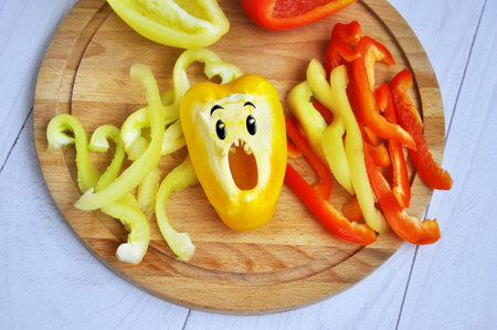 Sweet bell pepper sliced on a wooden chopping board.の写真素材