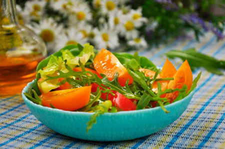 Vegetable salad with arugula on the kitchen table.の写真素材
