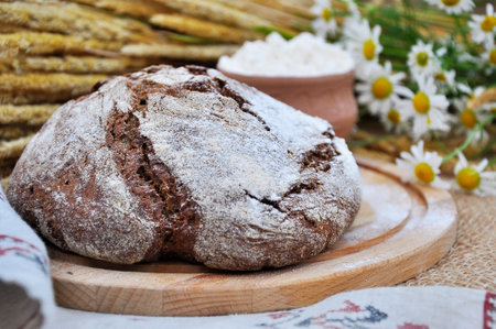 Wheat flour and brown bread on the table.の写真素材