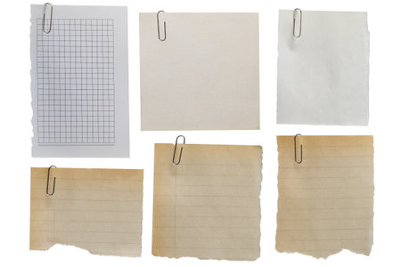 Set of old scraps of different types of paper with torn edges fixed with a paper clip on a transparent background.の写真素材