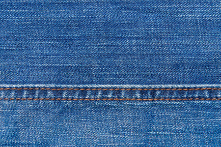 Close-up of blue denim fabric showing detailed texture and stitching. Perfect for fashion, textile, and design-related projects.の写真素材