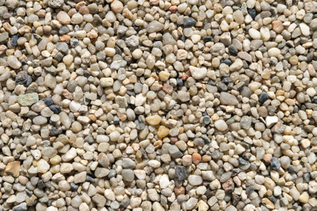 Close up view of small, multicolored pebbles creating a textured, natural background, ideal for design projects related to nature, construction, or landscapingの写真素材