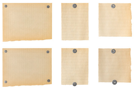 Collection of blank vintage lined paper sheets fixed with thumbtack, creating a nostalgic and textured backdropの写真素材