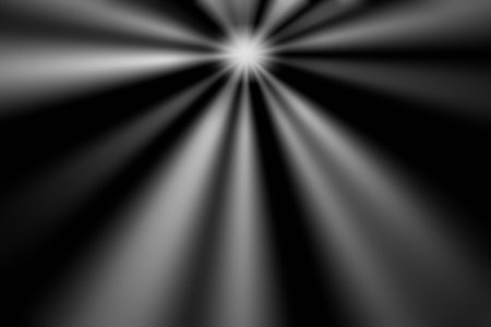 A warm white light glare emanates from the top of the image, casting beams of light across a black background.の写真素材