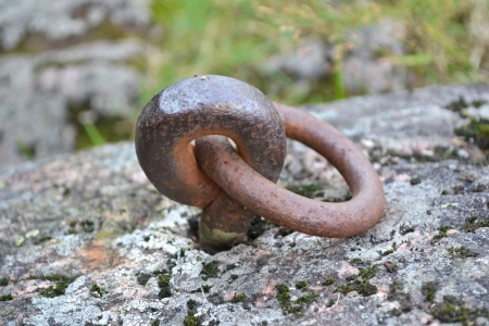 Old and rusty mooring ring for ships on dock
