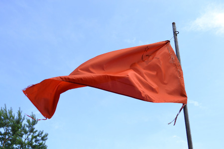 Red soviet flag on blue sky background.