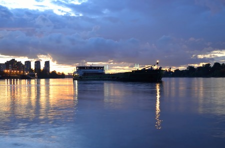 View of Neva River and river cargo ship at sunset on the outskirts of St. Petersburg, Russia.の写真素材
