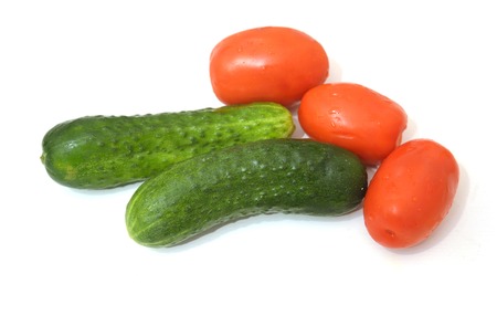Two cucumber and three tomatoes on a white background.の写真素材