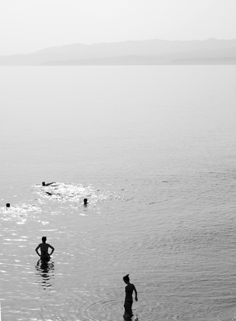 Silhouettes of people in Aegean Sea, Crete island, Greece. Black and white.の写真素材