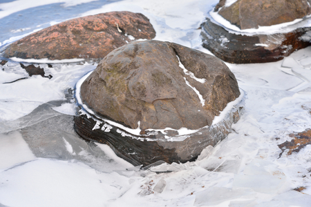 Granite stones on ice at winter day.の写真素材