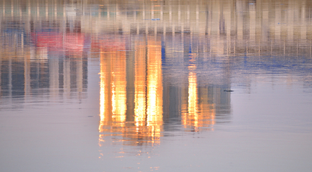 Reflection of a skyscraper at sunset in water.の写真素材