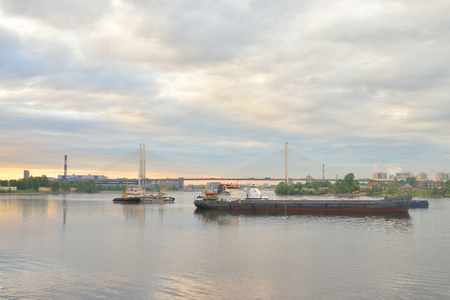 ST.PETERSBURG, RUSSIA - 18 MAY 2016: Cable-stayed bridge at sunset in St.Petersburg. In the foreground cargo ships.のeditorial素材