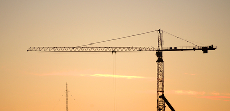 Construction crane silhouette at evening at sunset.の写真素材