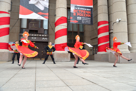 ST.PETERSBURG, RUSSIA - 9 APRIL 2017: Group of people in national costumes are dancing Russian dances on city street in the center of St. Petersburg.のeditorial素材