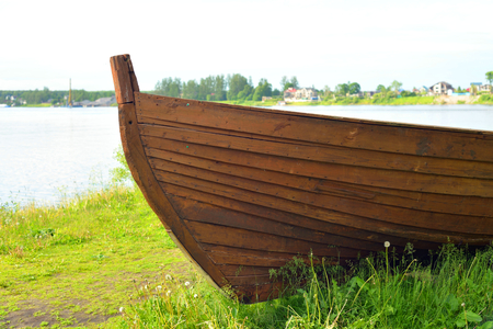 Wooden boat on coast of river at sunny summer day.の写真素材