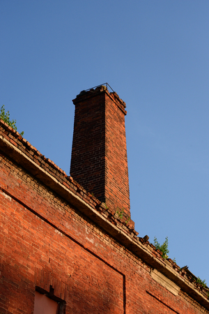Old brick pipe on blue sky background.の写真素材