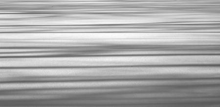 Snow background with shadows at sunny day. Black and white.