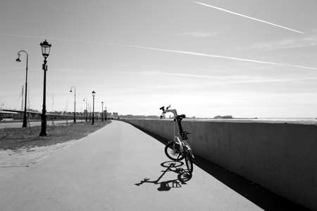 ST.PETERSBURG, RUSSIA - 17 MAY 2019: Bicycle Strida on embankment and Gulf of Finland of Baltic Sea, Russia. Black and white.のeditorial素材
