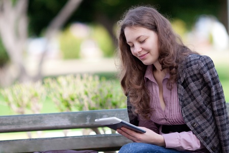 woman reading digital book at the parkの写真素材