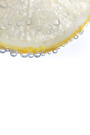 segment of lemon isolated on white with bulbes of waterの写真素材