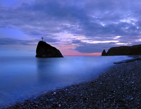 A little rock island in black sea at sunsetの写真素材