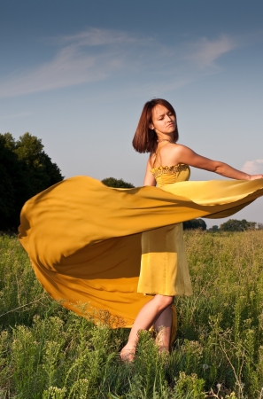 Stock Photo  Girl dressed in yellow dress at the fieldの写真素材