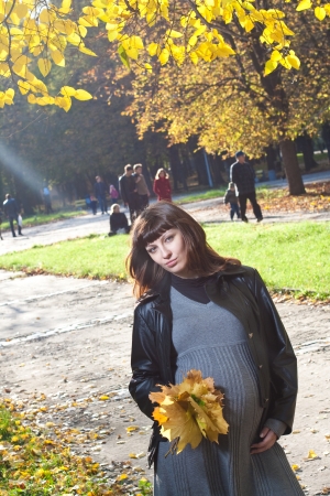 Pleasured pregnant woman in autumn park の写真素材