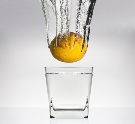 lemon splash in glass of water isolated on white background