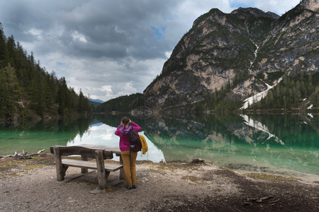 Travel hiker taking photo of Lake Braies (Lago di Braies) in Dolomites Mountains, Italy. Hiking travel and adventure.の写真素材