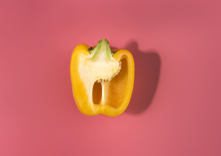 Natural organic yellow sliced bulgarian bell pepper on trend pink background.Top view.Healthy food concept. Flat lay.Copy space. Minimalism style.Vegetables Vitamins Rustic Style. Country Village Agricultureの写真素材