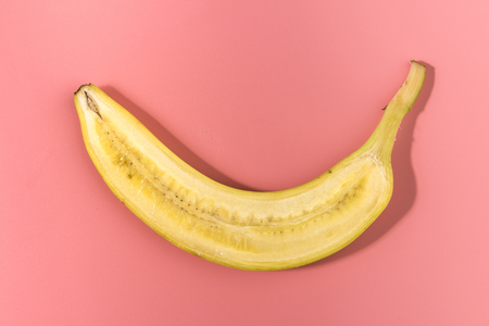 Banana sliced on pastel pink background. Minimal fruit concept. Caontrast shadowsの写真素材