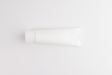 Blank white tube of toothpaste, cream or gel standing on white background. Branding mockupの写真素材