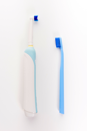 Manual Regular Toothbrush Against Modern Electric Toothbrush. Isolated on White Backgroundの写真素材