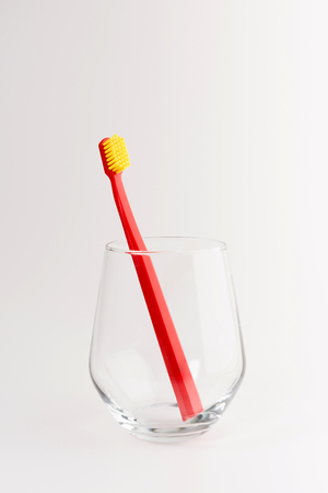 Cup with toothbrush on table isolated on background. Dental careの写真素材