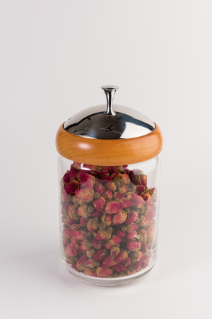 tea rose buds in the transparent jar isolated on white backgroundの写真素材