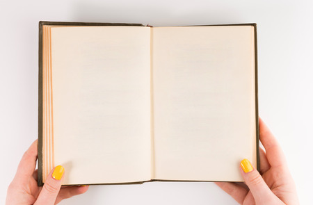 A woman (female) two hands hold an empty (blank) book spread isolated on white background, flat layの写真素材