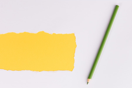 White torn paper over black background with pencilの写真素材